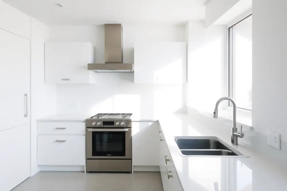 Clean kitchen with clear benchtops and polished stainless appliances